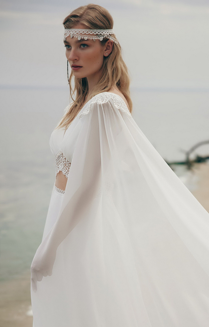 Bride in a lace wedding dress against the sea background